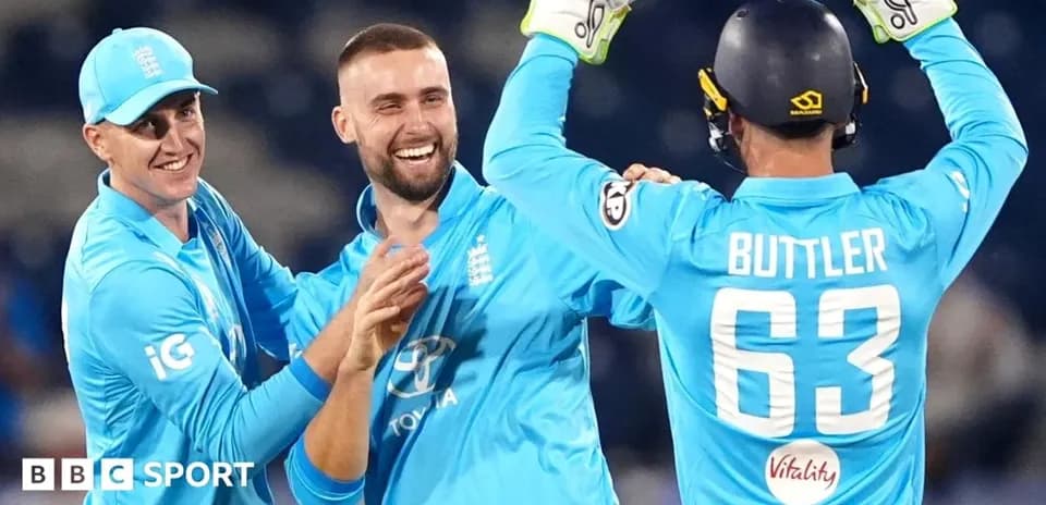 Three England players celebrating a wicket together