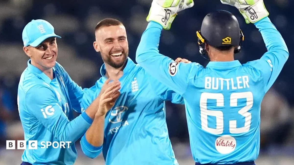 Three England players celebrating a wicket together