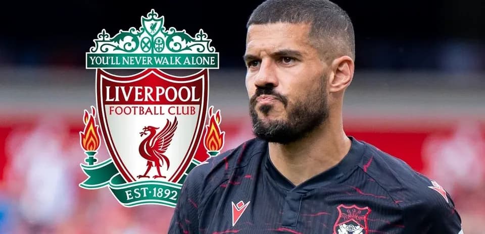 Player in Liverpool kit with club logo in background
