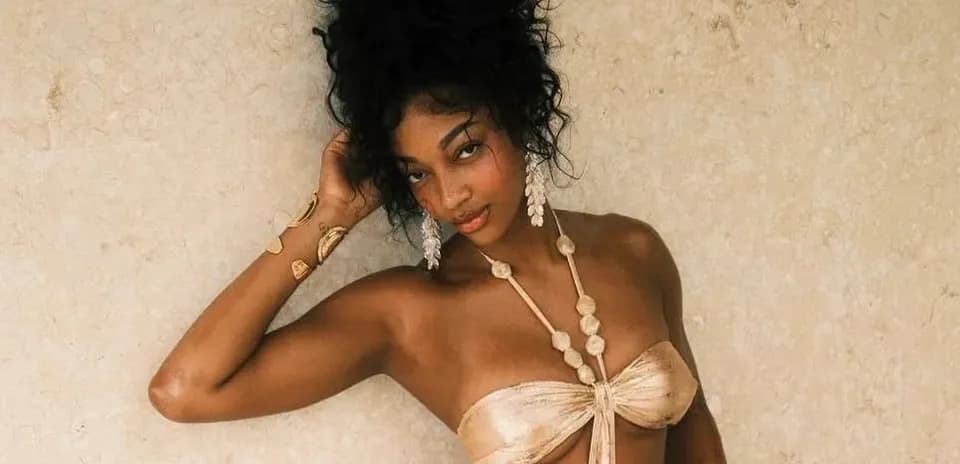 Model posing against a textured beige wall