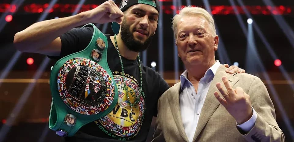 Boxer holding WBC belt with promoter in arena