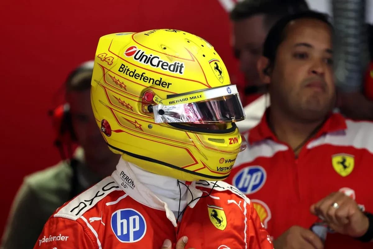 Driver in Ferrari suit wearing helmet in garage Driver in Ferrari suit wearing helmet in garage