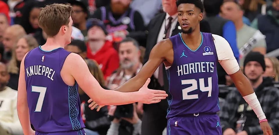 Two Hornets players exchanging handshakes during game