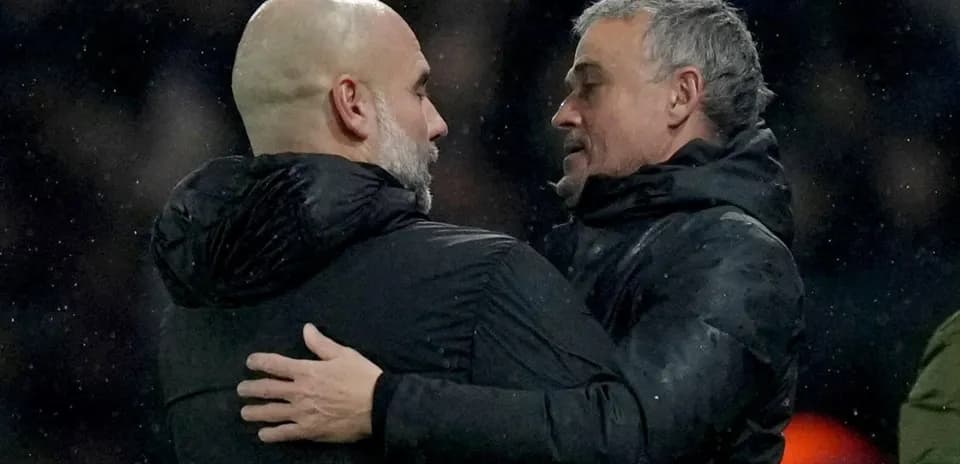 Two coaches embracing on the sidelines after match