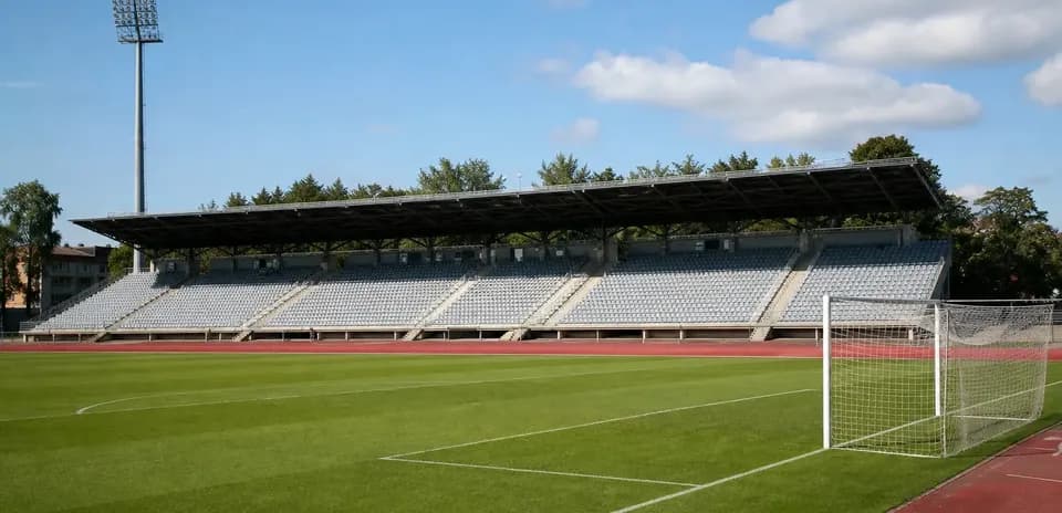 Empty football stadium with seating and goalpost