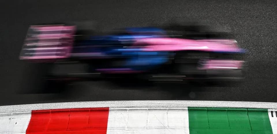 Race car speeding past track curbing at event