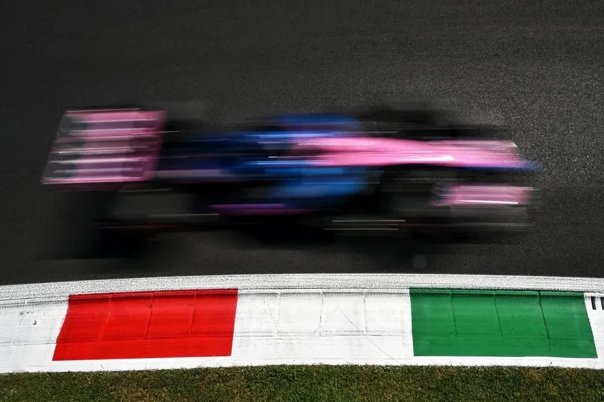 Race car speeding past track curbing at event