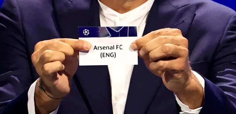 Official holding Arsenal FC draw card during event