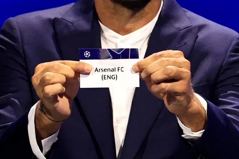 Official holding Arsenal FC draw card during event