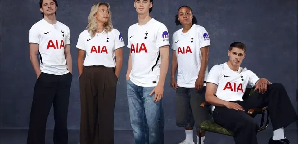 Five individuals wearing Tottenham Hotspur jerseys posing together