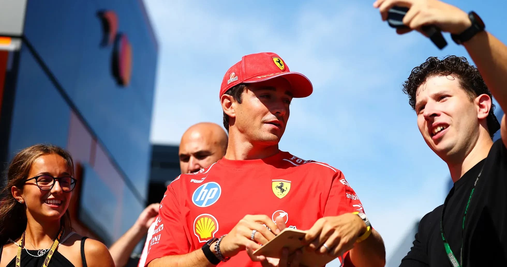Driver in Ferrari shirt interacting with fans