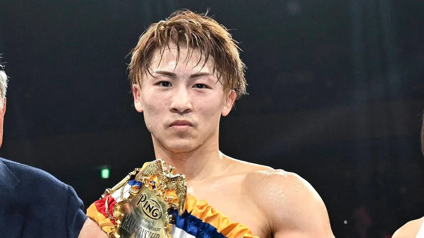 Boxer holding championship belt after winning match