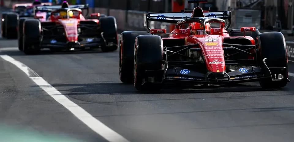 Two Ferrari cars driving on the pit lane