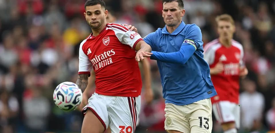 Player in red and blue competing for the ball