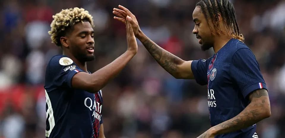 Two PSG players high-fiving during a match