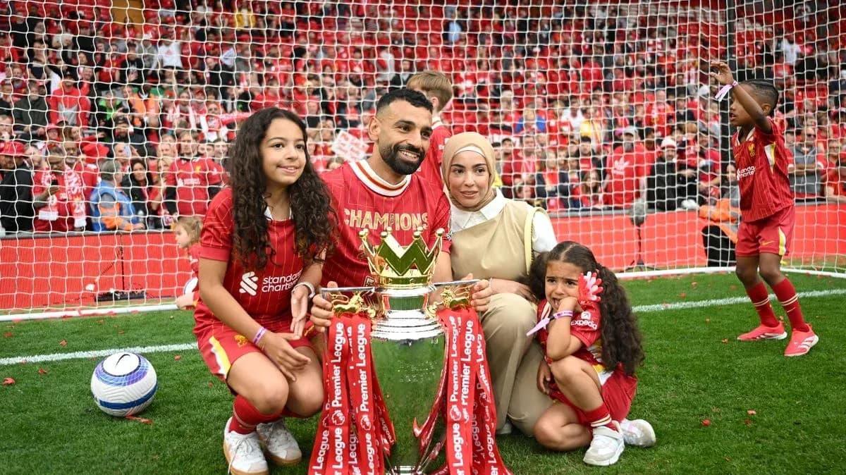 Player celebrating with family and trophy on field