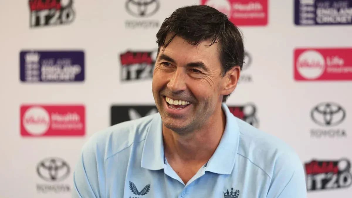 Cricket coach smiling at press conference
