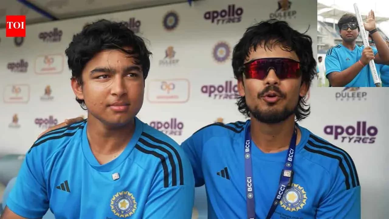 Two cricket players in blue jerseys during interview