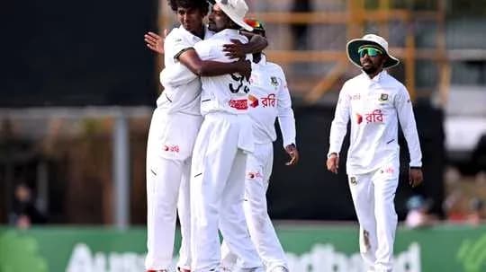 Players celebrating a wicket during a cricket match