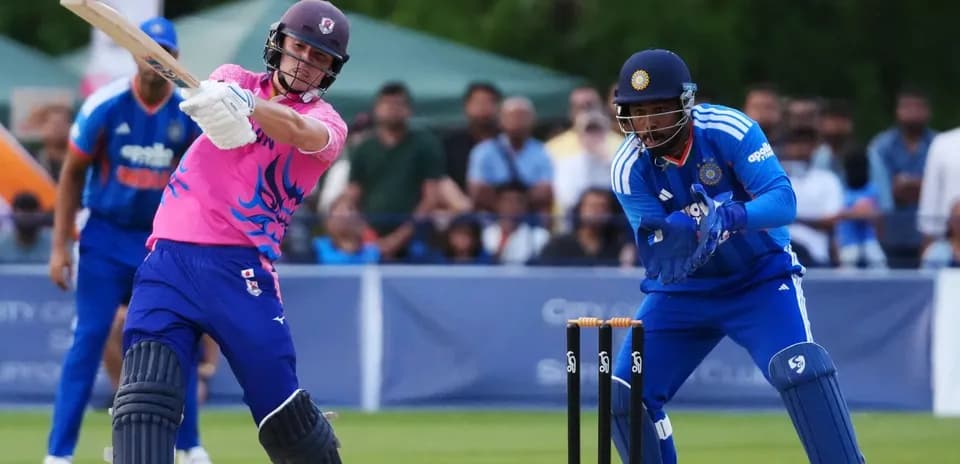 Batsman playing a shot while wicketkeeper prepares