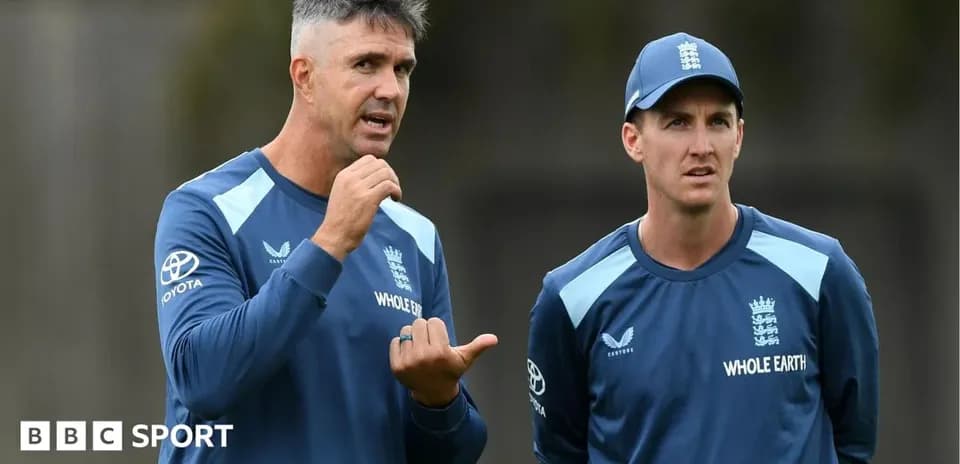 Cricket coach discussing strategy with player