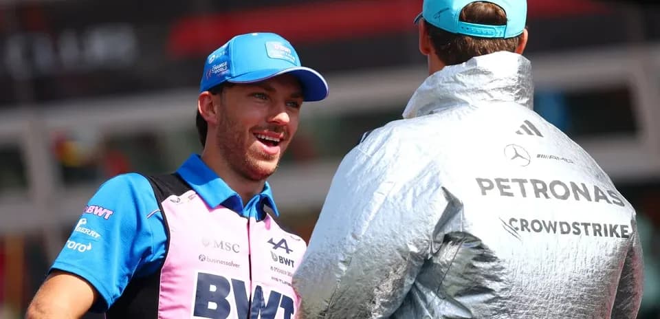 Two Formula 1 drivers chatting in paddock area
