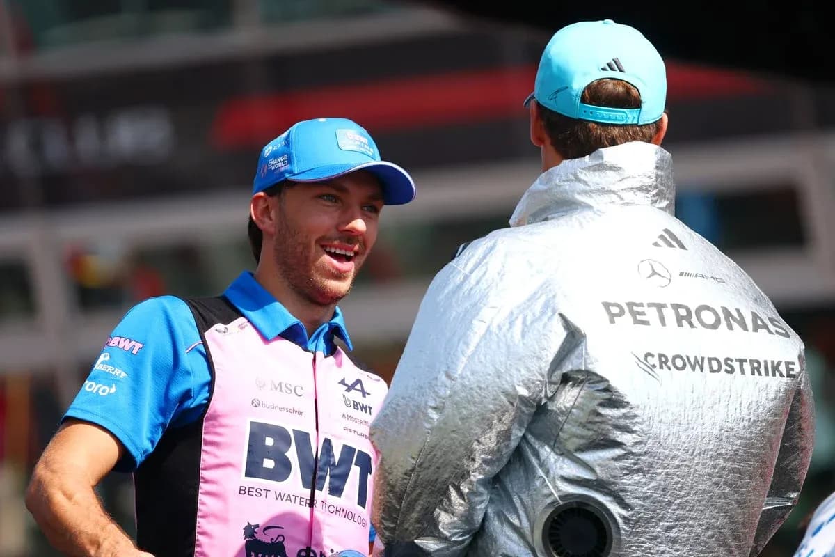 Two Formula 1 drivers chatting in paddock area