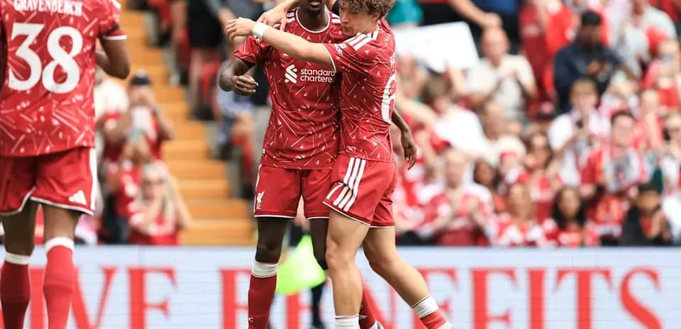 Two Liverpool players celebrating on the pitch