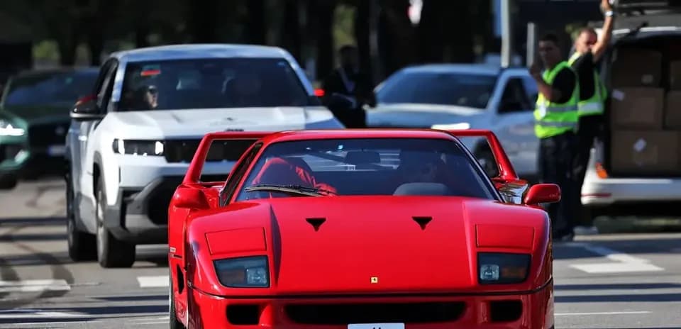Red Ferrari F40 driving on urban street