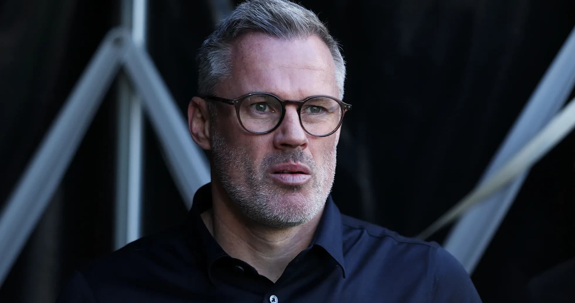 Man with glasses looking thoughtfully off-camera