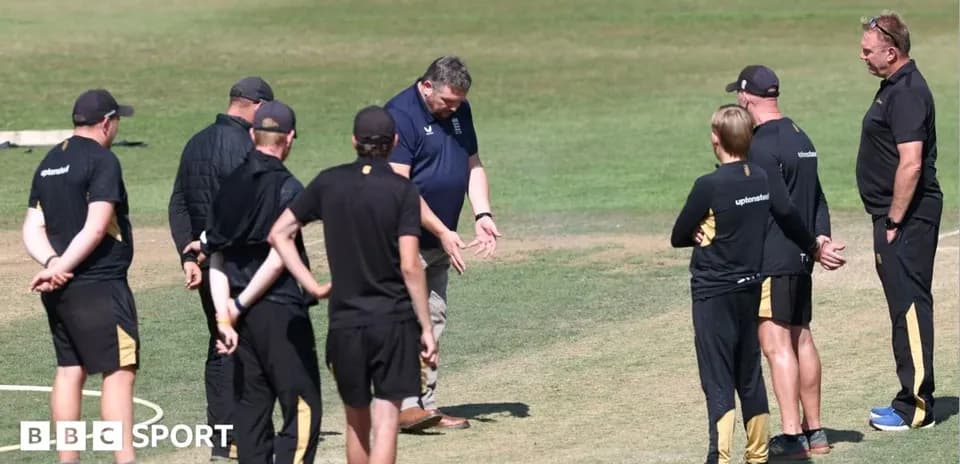 Coaches discussing strategy on cricket field