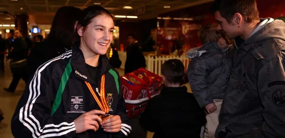 Athlete holding medal in busy airport setting