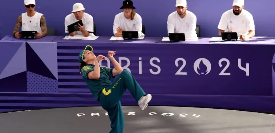 Athlete performing at Paris 2024 event with judges