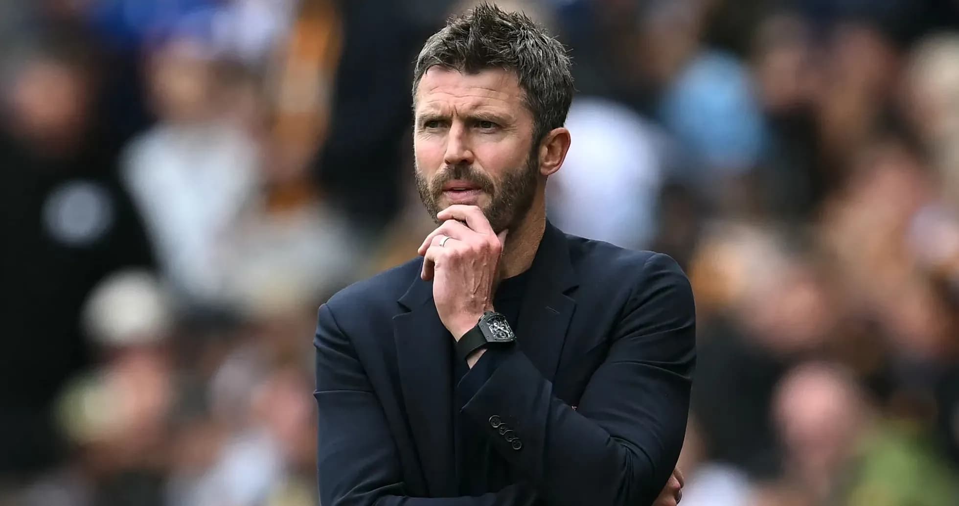 Coach observing the match with thoughtful expression
