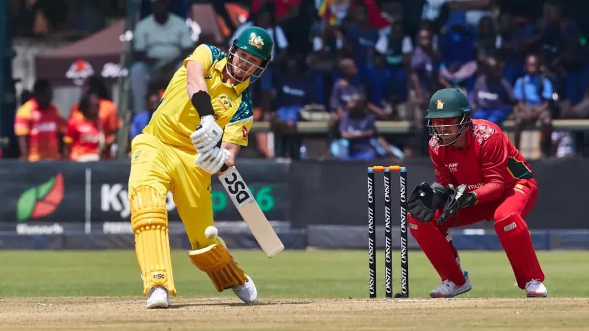 Batsman hitting ball while wicketkeeper prepares to catch