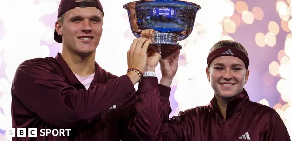 Two athletes holding a trophy during celebration