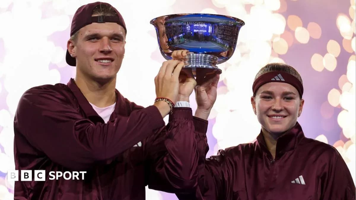 Two athletes holding a trophy during celebration