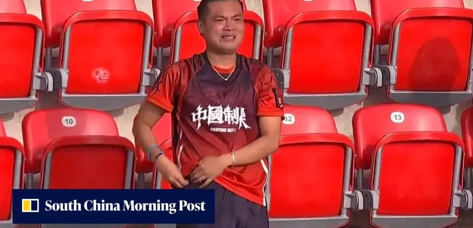 Fan in orange shirt standing in empty stadium seats