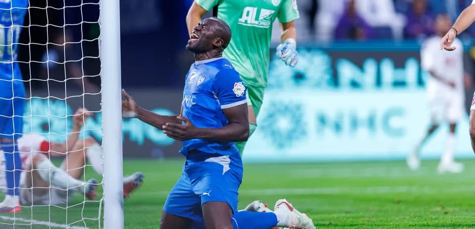 Player kneeling near goal post after missing chance