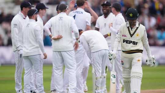 Pakistan batsman walking past celebrating England players