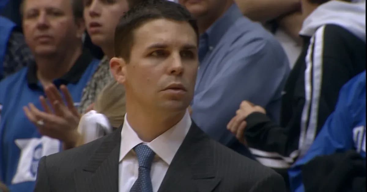 Coach observing game with fans in background