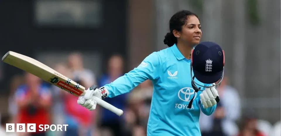 Cricketer celebrating with bat and helmet raised