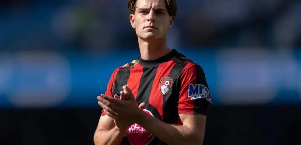 Player applauding on the pitch wearing team jersey