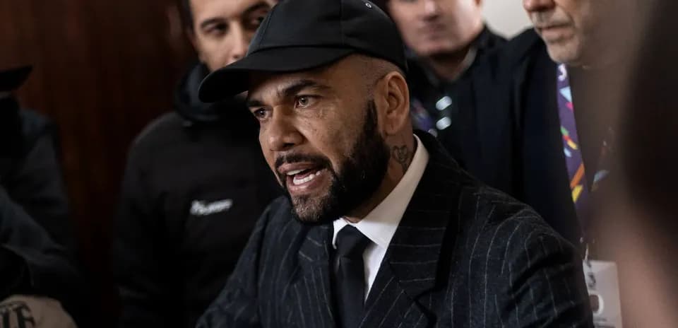 Man in suit speaking to crowd of onlookers