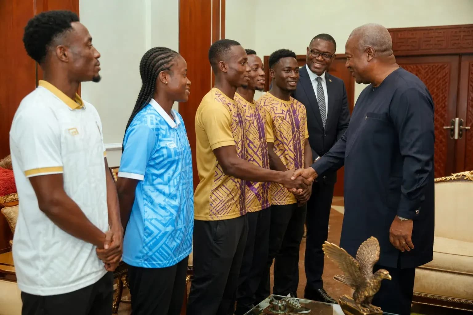 Athletes meeting with dignitaries in formal setting