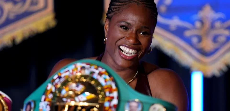 Boxer holding championship belt and smiling proudly