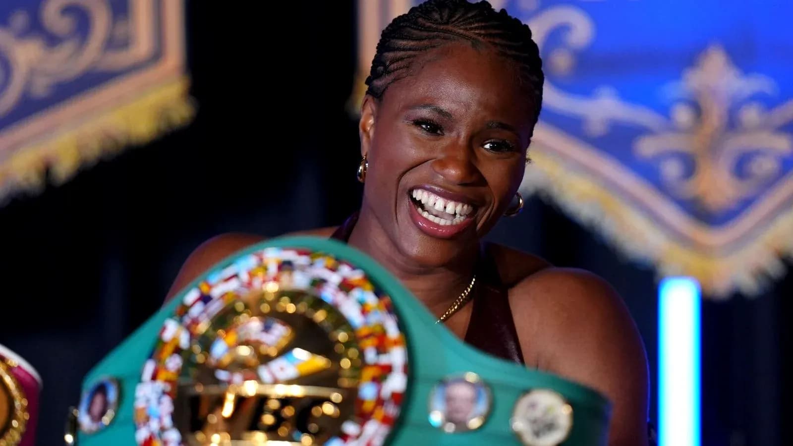 Boxer holding championship belt and smiling proudly