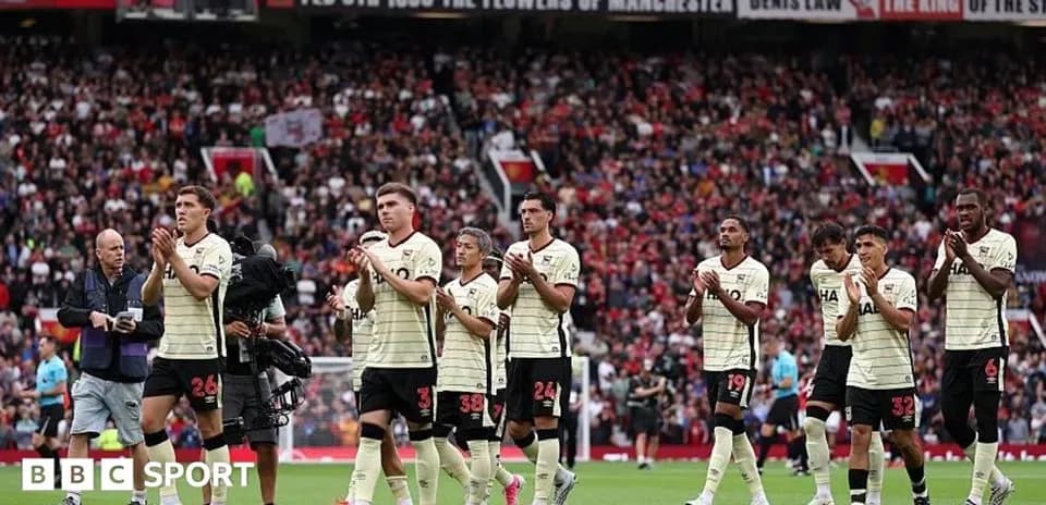 Players applauding fans at stadium after match