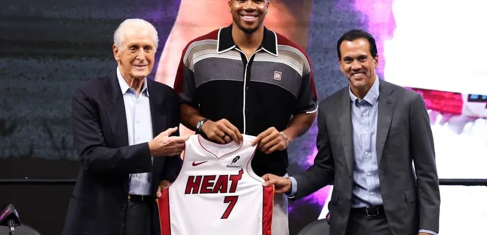 Player holding Miami Heat jersey at press conference