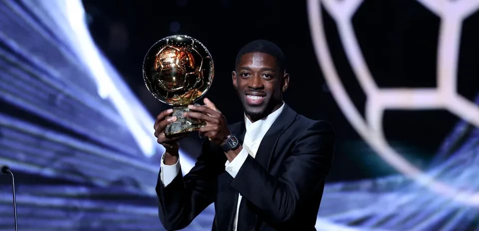 Player holding Ballon d'Or award on stage